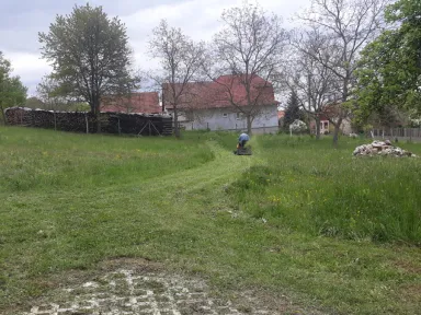 Priebeh prác. Traktorová kosačka ide síce pomaly, ale isto. 