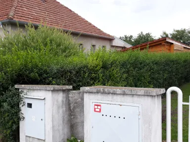 Záber od ulice na živý plot pred strihaním.